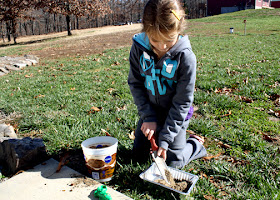 Tessa began by scooping a mixture of sand and dirt into a small disposable pan.