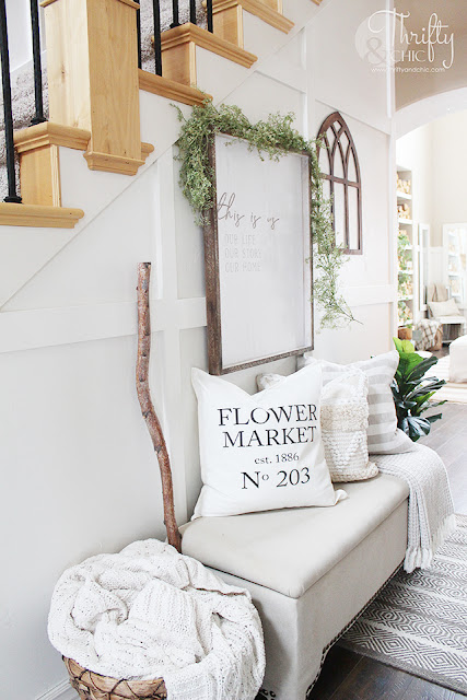 entry way with stairs, bench, wood wall art and plant