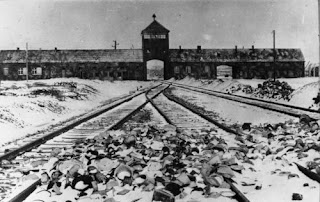 Fotografía de la entrada del campo de concentración nazi de Auschwitz y las vías ferroviarias que conducían a él