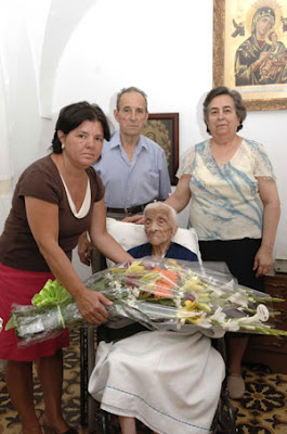 La alcaldesa de Villanueva de Córdoba entrega un ramo de flores a Carmen Romero en su último cumpleaños