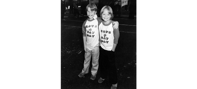Two young boys wearing t-shirts reading "Have a Gay Day" at the SF gay pride parade circa 1977