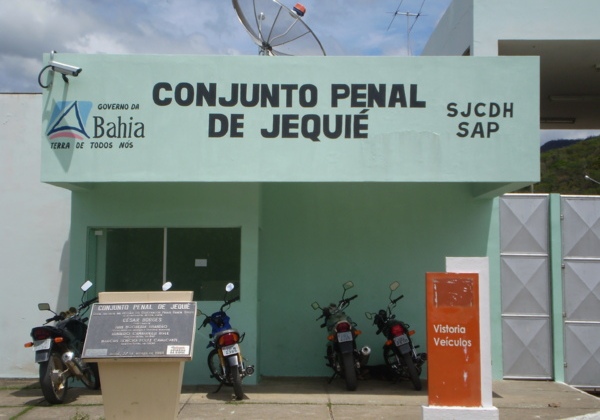 A frente do conjunto penal de Jequié na Bahia, tem quantro motos estacionadas na frente, com paredes verde claro.