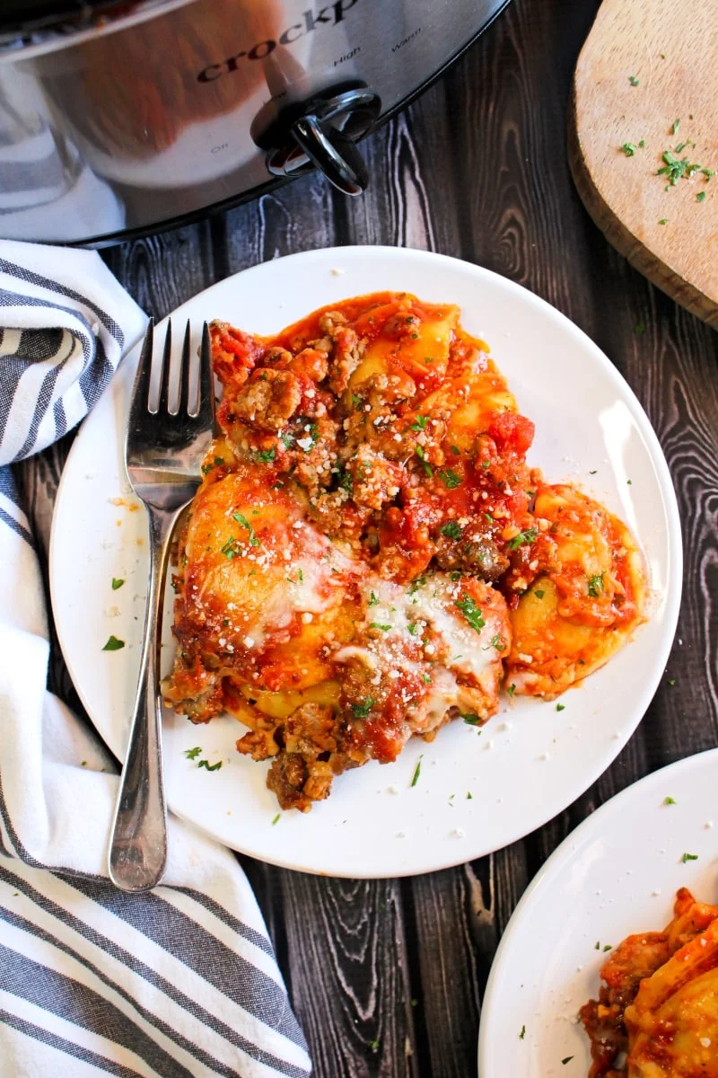 Crockpot Ravioli Lasagna is the easiest shortcut lasagna you will ever make. With just a few simple ingredients, you will want to make this ravioli casserole all the time! #ravioli #crockpotrecipes #slowcooker