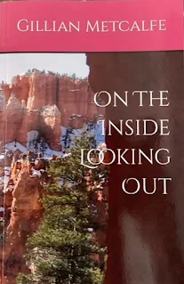 Snow dusted mountains as seen looking out through a natural rock archway, the front cover design of my second book.