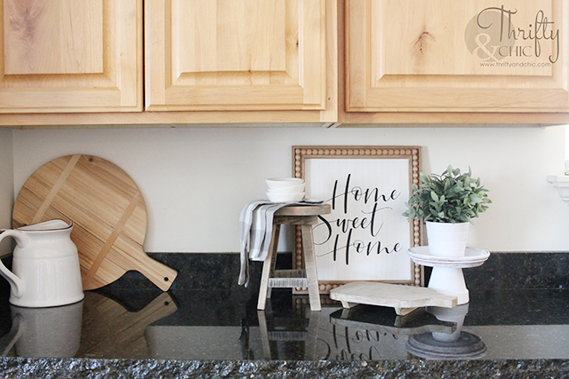 kitchen with knotty alder cabinets, white board and batten island, and black granite counter tops with an unfinished edge.