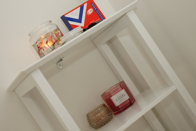 Candles and other small accessories on a shelving unit in the treatment room.