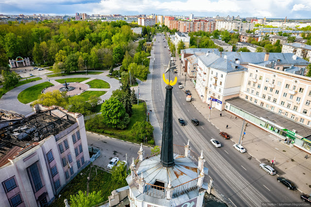 Шпиль со звездой на фоне дороги и парка