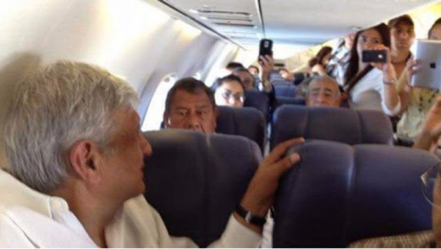 AMLO es descubierto en avión y pasajeros aprovechan para sacarse fotos con él.