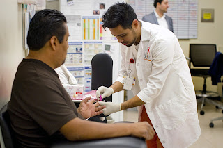 Medical Assistant Hector Reyes administers an HIV blood test to a patient at St. John's Well Child and Family Center on March 18, 2014 in Los Angeles.