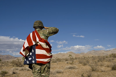 Saluting wrapped in the American flag