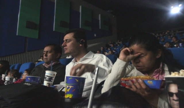 Personas invidentes en una sala de cine, con audiodescripción en sus oídos