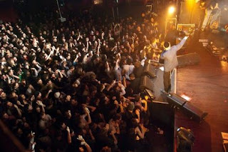 Screen shot image of the band playing live in front of large crowd