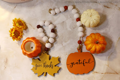 Fall decorations for tiered tray laid out on a table