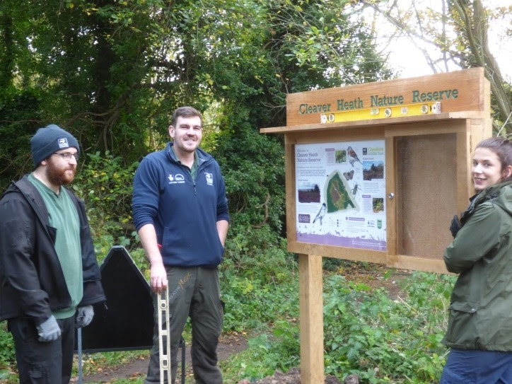 Putting the noticeboard in place at Cleaver Heath