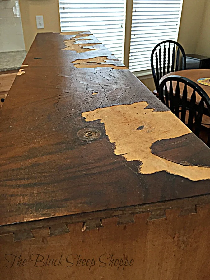 The wood veneer on the front of the dresser has significant damage.