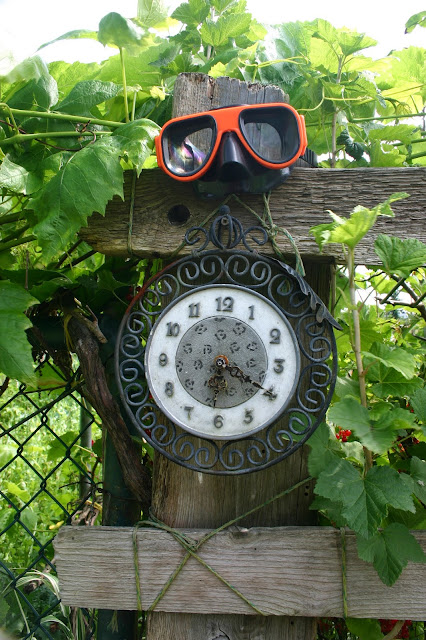 Garden decor with found objects: clock and goggles