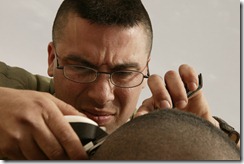 Sgt. Kimokeo K. Yogi, a self-taught barber, cuts it close outside the 1st Force Service Support Group's command center in Camp Victory, Kuwait, on Feb. 16, 2004. Yogi, a 26-year-old native of Honolulu, has been moonlighting as a barber since 1995, shortly after joining the Marine Corps, and cut his fellow Marines' hair during Operation Iraqi Freedom in addition to his regular duties. Yogi, currently working in the 1st FSSG's units movement control center, is one of approximately 25,000 Marines deploying to Iraq in coming months. (Photo by Staff Sgt. Bill Lisbon)