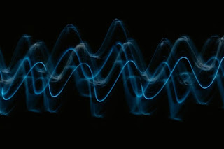 Several sinusoidal out-of-phase waves on a black background