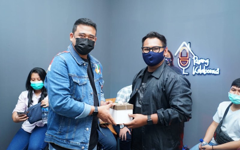 Bobby Nasution menyerahkan hadiah kepada pemenang lomba desain baju official tim pemenangan , Ihza Mahendra di Ruang Kolaborasi Media Center Jalan Cik Ditiro Medan, Senin (26/10/2020).