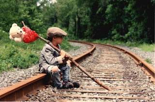 Kid on railroad tracks running away from home with hobo pack 