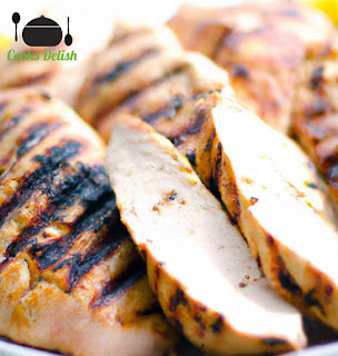 A close-up shot of sliced grilled chicken breast with a crispy char on the outside and juicy tender on the inside.
