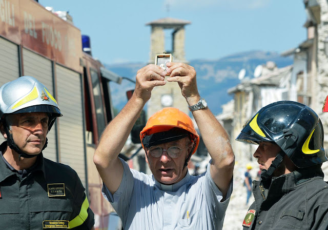 O padre Savino de Amatrice segura a 'Madonna de Filetta' delicadíssima imagem recuperada na igreja de Santo Agostinho inteiramente destruída