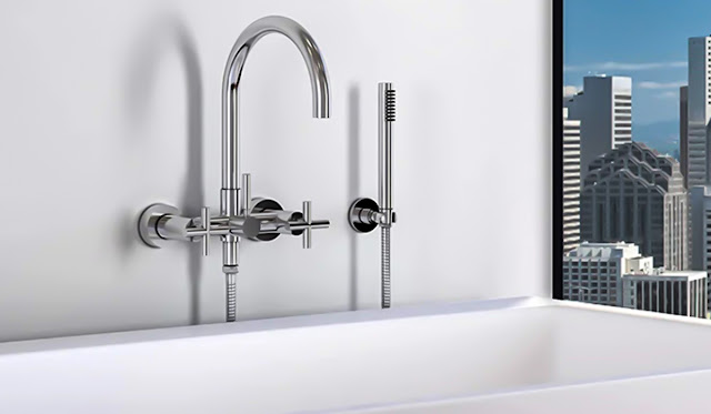 Bathtub faucet on a soaking tub in a white bathroom.