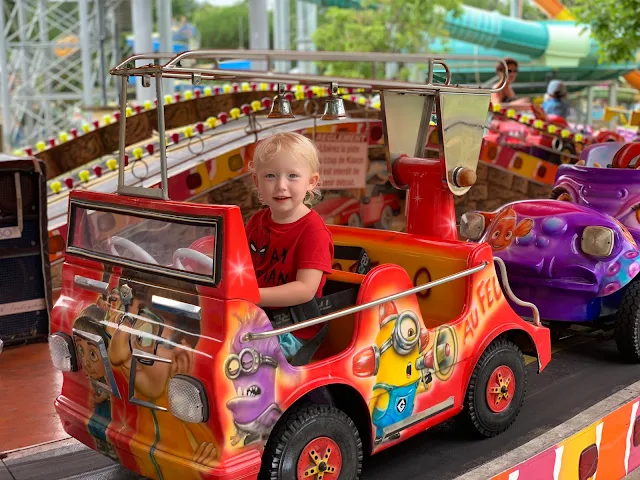 3 year old child on a fire engine as part of a ride at the Parc Jacquou theme park in France Dordogne