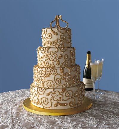 Four tier white wedding cake with gold swirl pattern