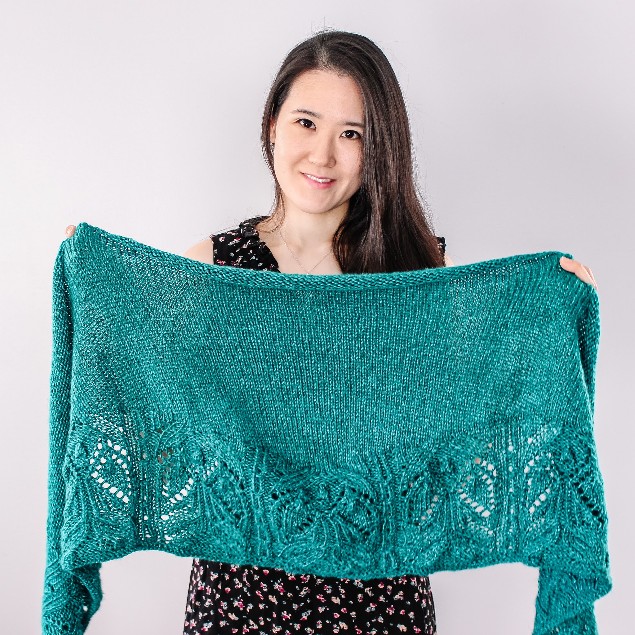 Designer showing the Emerald Shawl knit pattern.