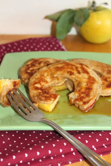 Fork cutting apple ring pancakes.