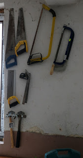 Tools hung on the new wall by the bench