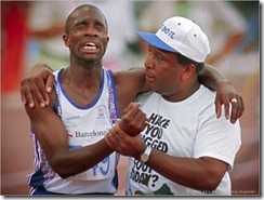 Derek Redmond of Great Britain is in agony as he is helped to the finish line by his father, Jim, after tearing his hamstring muscle in the semi-finals of the men's 400 meter run.<br /><br />Redmond collapsed about half way through the race with the injury, but got up, determined to finish despite the pain. His father came out of the stands and onto the track to help his son. Redmond initially tried to push him away, not realizing who he was, but then heard a familiar voice. "Derek, it's me" his father said.<br /><br />Redmond told his father "I've got to finish this race." His father said "If you're gonna finish the race, we'll finish it together."<br /><br />With his father's help, Redmond made it to the finish line.<br /><br />Redmond, a brilliant runner whose career was plagued by injuries, had previously suffered a similar fate during qualifying for the 400 meter race in the Summer Olympics in Seoul, South Korea. In a qualifying heat for the 400 meter race, he pulled an Achilles tendon, an injury that led to five surgeries.<br /><br />Later, watching a video of that 1992 Olympic race, Redmond said "I don't think I've ever cried so much in my life. It's more embarrassing than anything else--men don't cry."<br /><br />Photo by Jerry Lodriguss / The Philadelphia Inquirer<br /><br /><br />