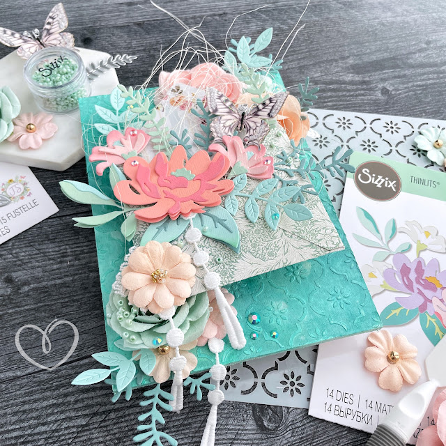 Mixed media panel with a Distress Spray and stenciled paste background, an envelope with die cut flowers and leaves, a Reneabouquets butterfly, and Prima Marketing flowers.