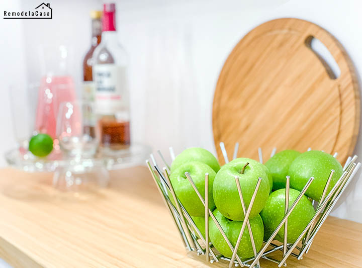 modern metal fruit bowl full of green apples