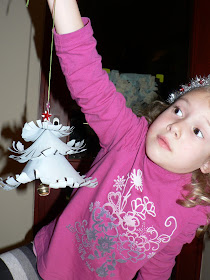child proudly showing finished christmas craft decoration