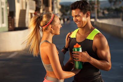 Couple smiling at each other on the road after workout