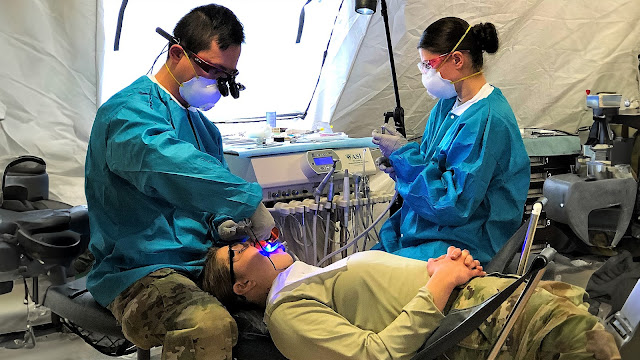 Army Maj. Yu-Sheng Chen, a comprehensive dentist, and Sgt. Jessica Rogowski, a dental assistant, perform routine and urgent dental care in a field environment during a recent Field Training Exercise held at Baumholder, Germany. (Photo courtesy of Munson Army Health Center Public Affairs)