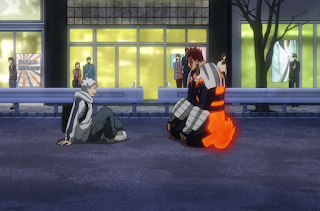 Natsuo sitting on the street, his father, Endeavor, kneeling before him.