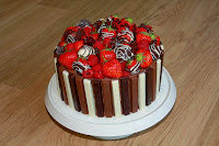 Chocolate and raspberry Kitkat gateau, topped with raspberries and chocolate-dipped strawberries