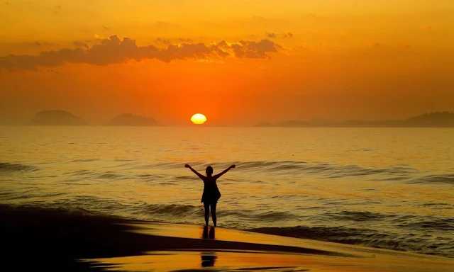 amanhecer na praia com mulher nas ondas doa praia