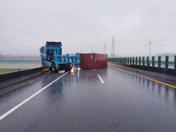 ▲許姓男子駕駛聯結車，疑雨天打滑失控撞上外側護欄，造成全車有如折甘蔗般，橫躺整個車道，造成北上車道封閉。（圖／彰化縣消防局提供）