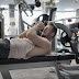 Concentrated muscular sportsman preparing for bench press in gym