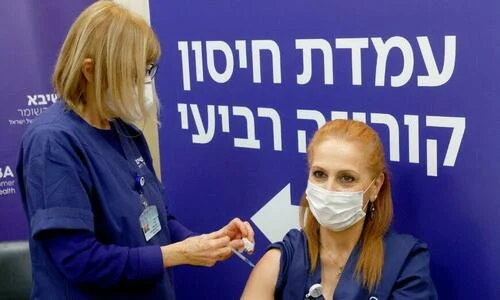 An Israeli nurse receives a fourth dose of the Pfizer-BioNTech COVID-19 vaccine at the Sheba Medical Center in Ramat Gan near Tel Aviv, on Dec. 27, 2021.