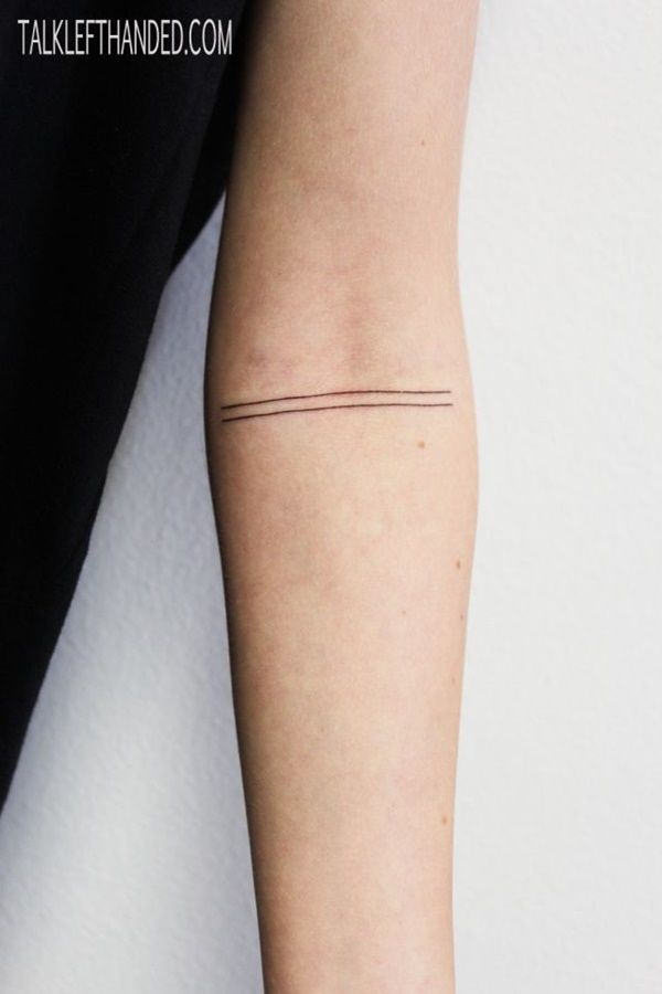 Duas finas linhas pretas são marcadas para o portador do antebraço neste tatuagem.