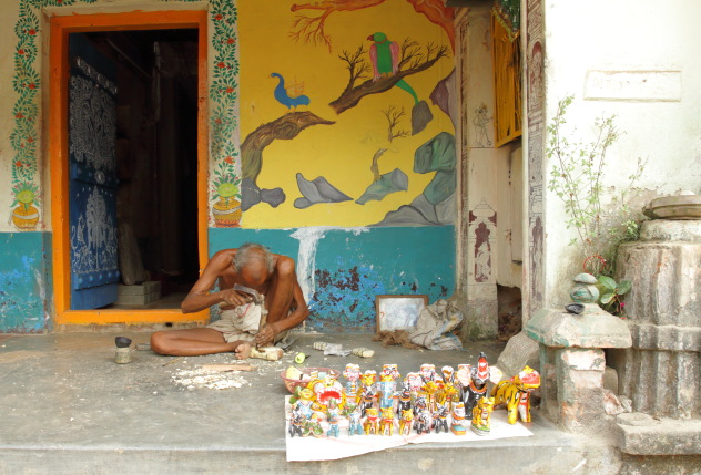 An elderly Raghurajpur artisan who is creating wooden toys