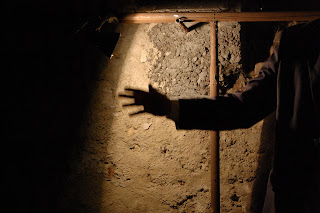 Фотография от представлението "Въображението мъртво си представете" от Самуел Бекет, детайл на човешка ръка на тъмен фон