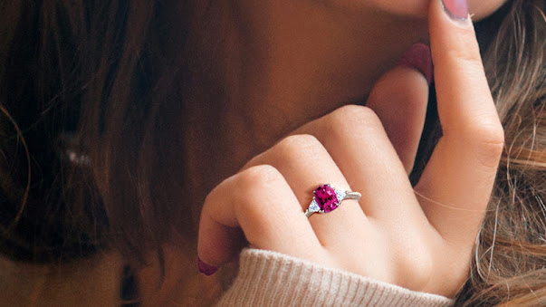 a pink engagement ring on a finger
