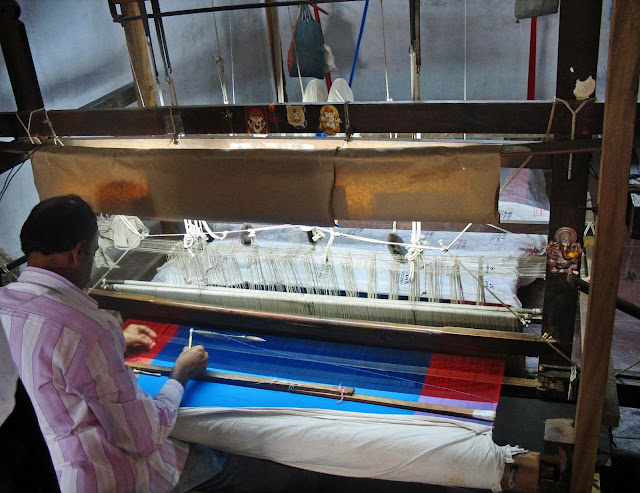 weaver at work on a manual loom