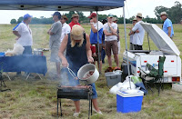 Martie finishing off the cooking while the hungry start queueing for lunch